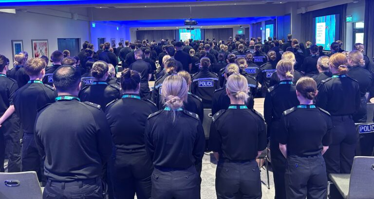 A room with 229 new police detectives - wearing policing uniforms. The photo has been taken from the back of the room so none of the officers are identifiable, given the covert nature of Counter Terrorism.