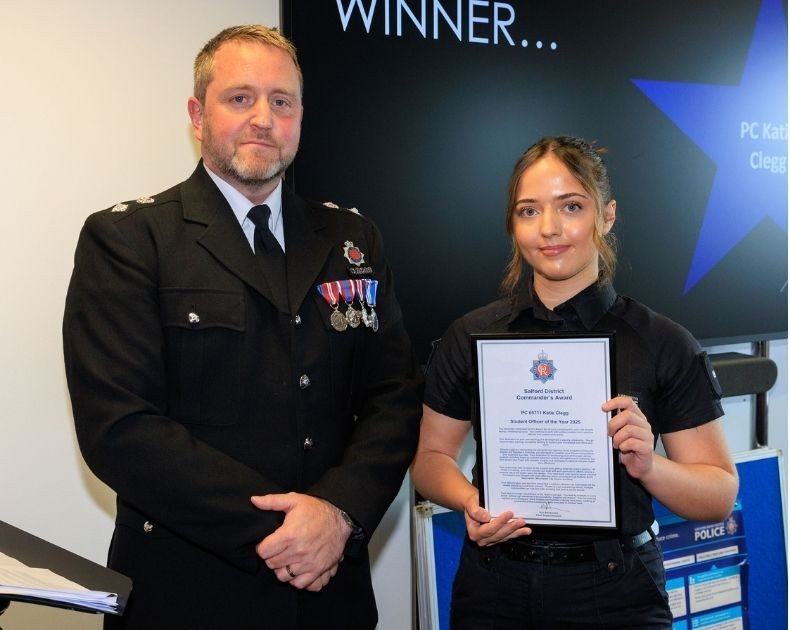 Katie Clegg stands next to her Chief Superintendent, holding a certificate that reads 'Student Officer of the Year'.