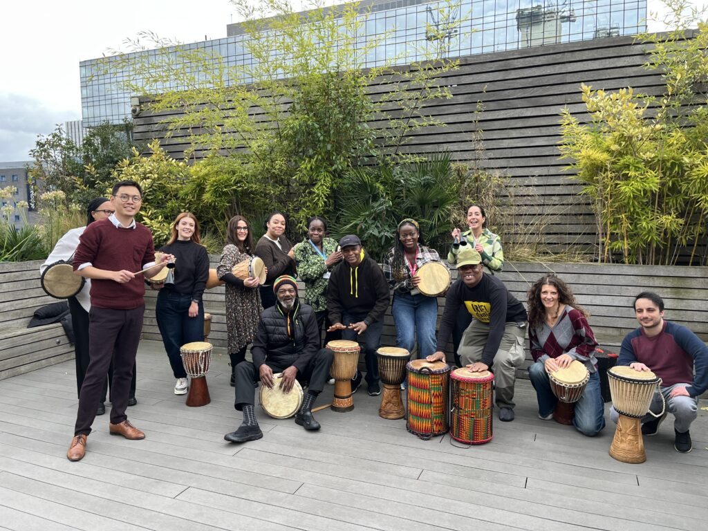 Police Now staff and IRIE! drumming group pose together for a photo.