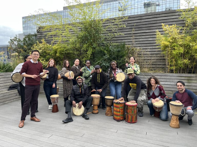 Police Now staff and IRIE! drumming group pose together for a photo.